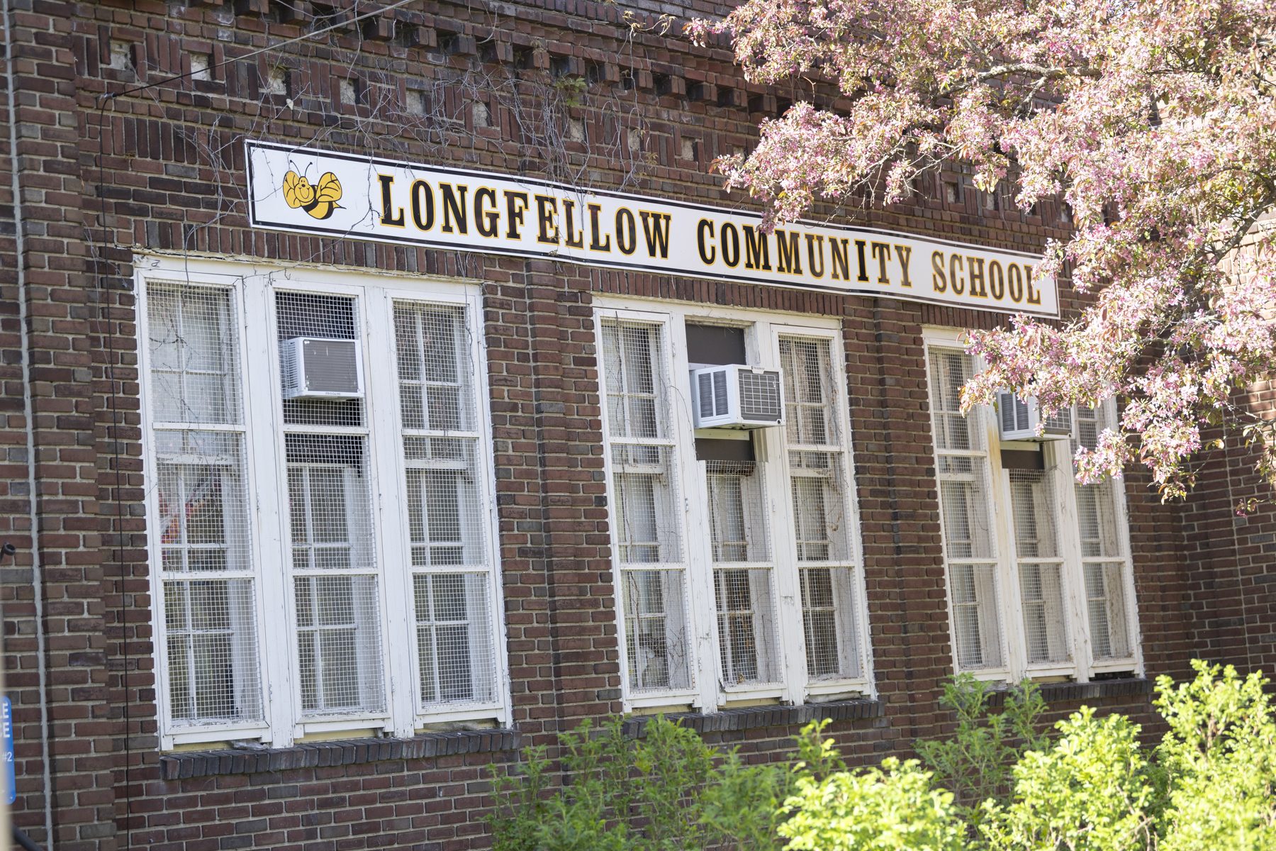 Longfellow’s brick school building on East 31st Street, with trees in bloom